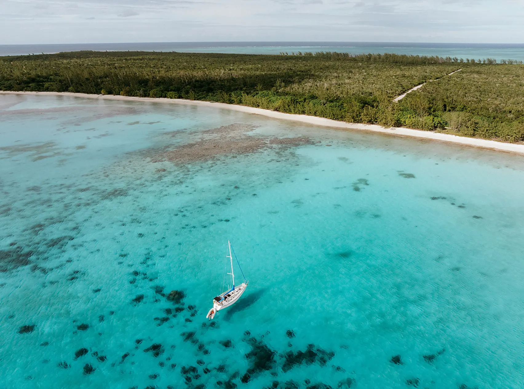 Vue aérienne d’un voilier dans les eaux turquoise des Caraïbes
